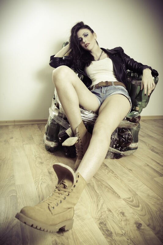woman in leather jacket sitting on bottles
