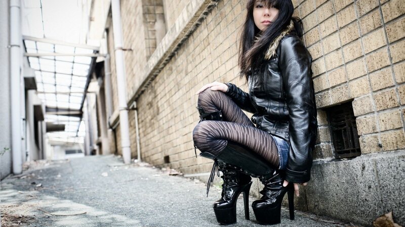 woman in leather jacket squatting