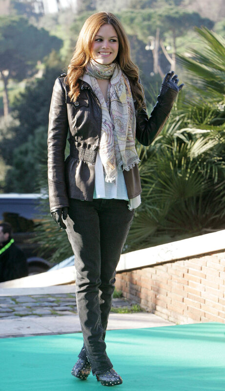 woman in leather jacket waving