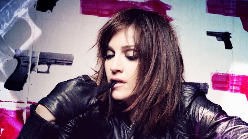 woman in leather jacket with guns