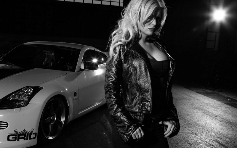 woman in leather jacket with sports car