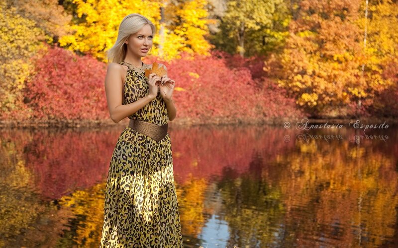 Woman in leopard dress by autumn lake
