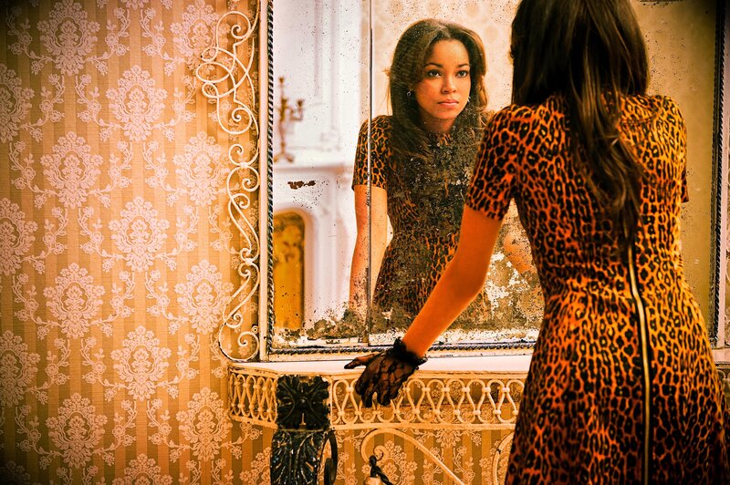 woman in leopard dress looking in mirror
