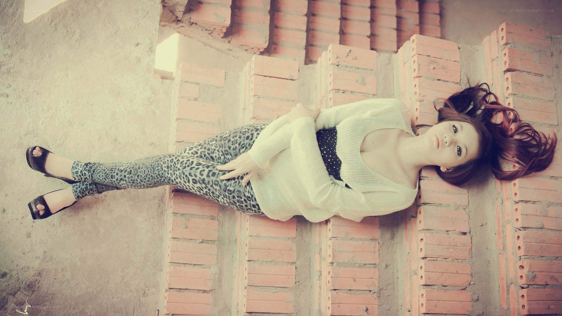 woman in leopard pants lying on bricks