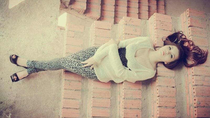 woman in leopard pants lying on bricks