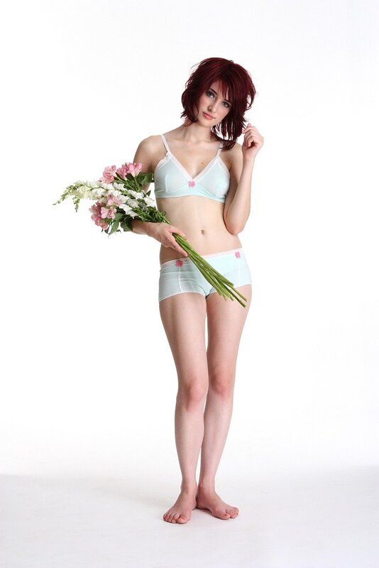 woman in light blue lingerie holding flowers