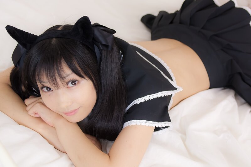 woman in maid costume lying on bed