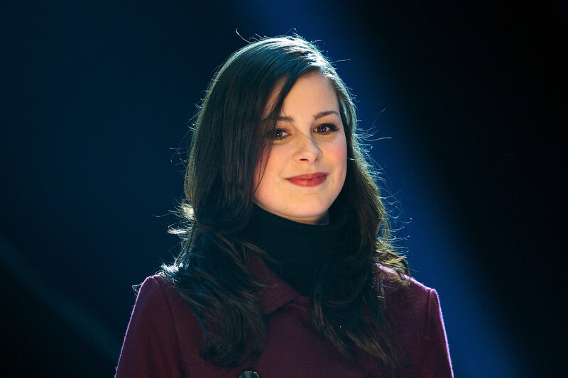 woman in maroon coat smiling