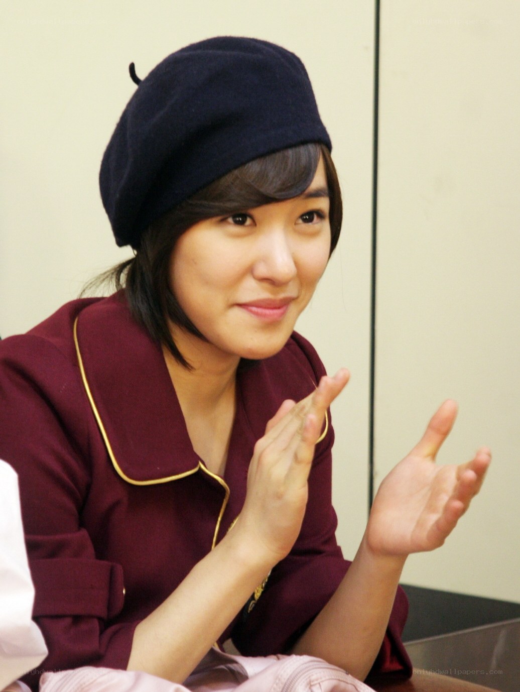 woman in maroon jacket clapping