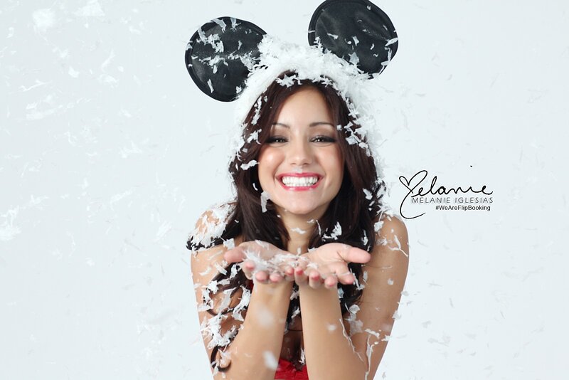woman in mickey mouse ears blowing snow