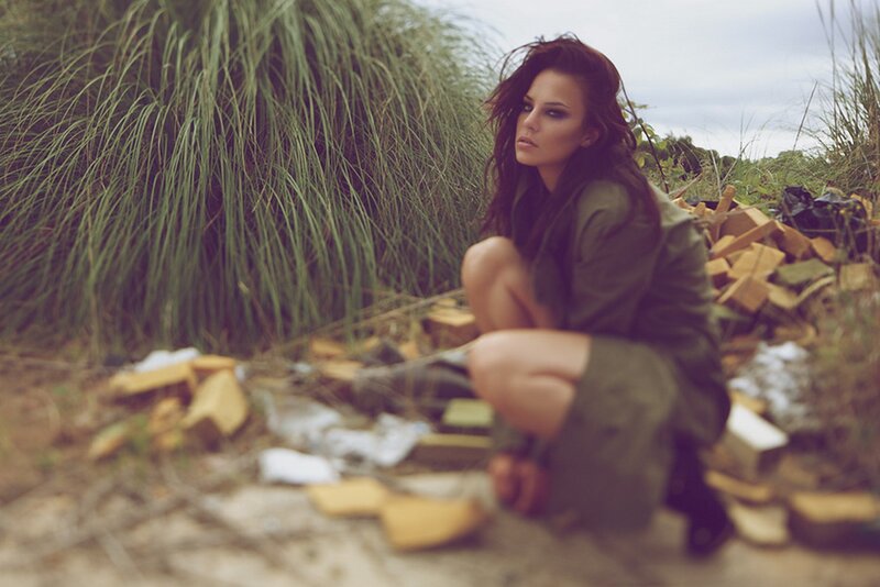 woman in military jacket crouching