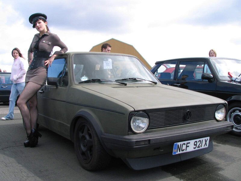Woman in military-style outfit with car