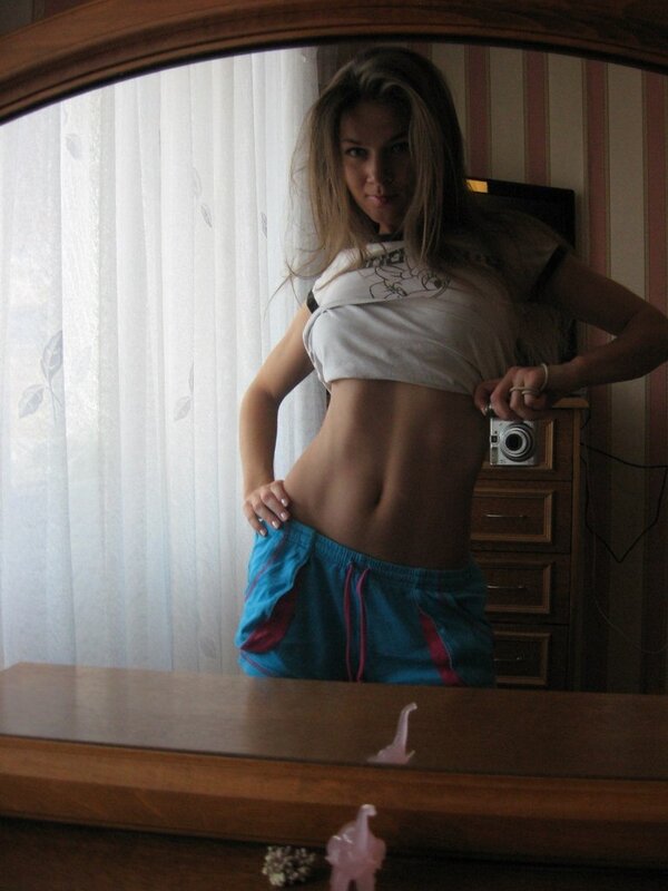 woman in mirror showing abs