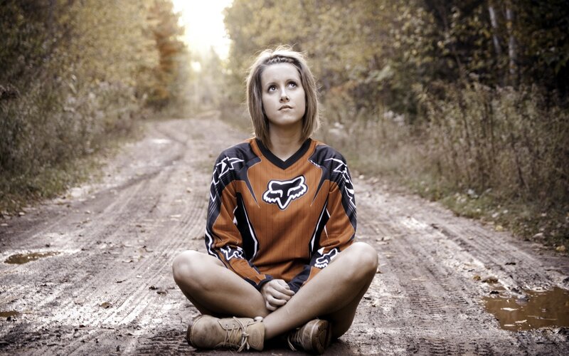 woman in motocross jersey on dirt road