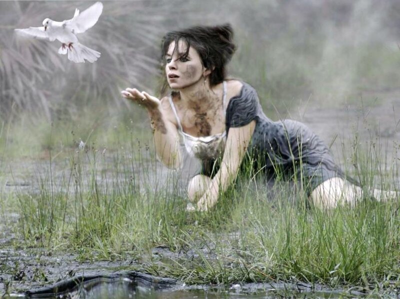 woman in muddy field with dove