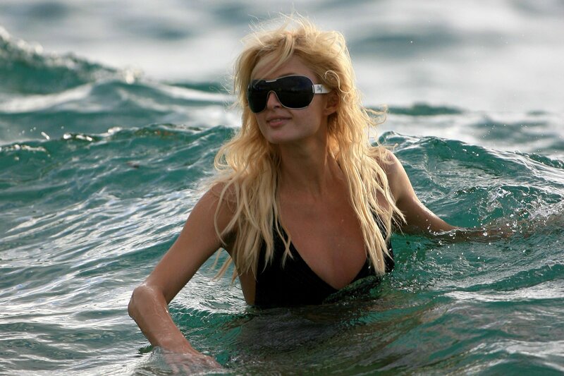 Woman in ocean wearing sunglasses