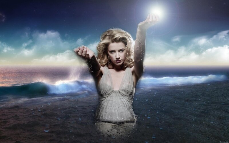 woman in ocean with glowing hands