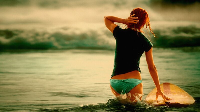 woman in ocean with surfboard