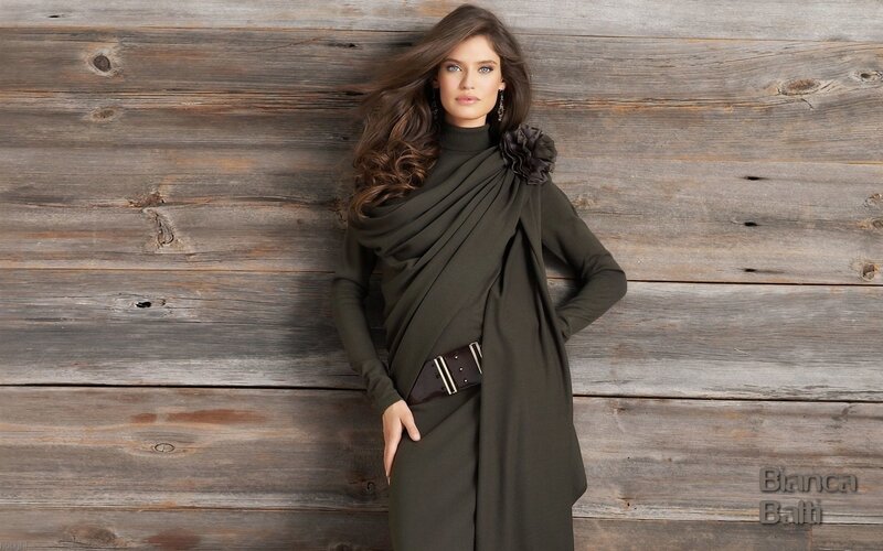 woman in olive dress against wood