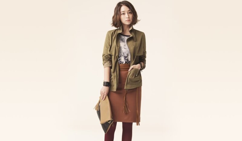 woman in olive jacket and brown skirt