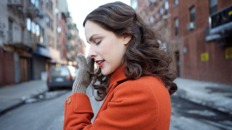woman in orange coat on street