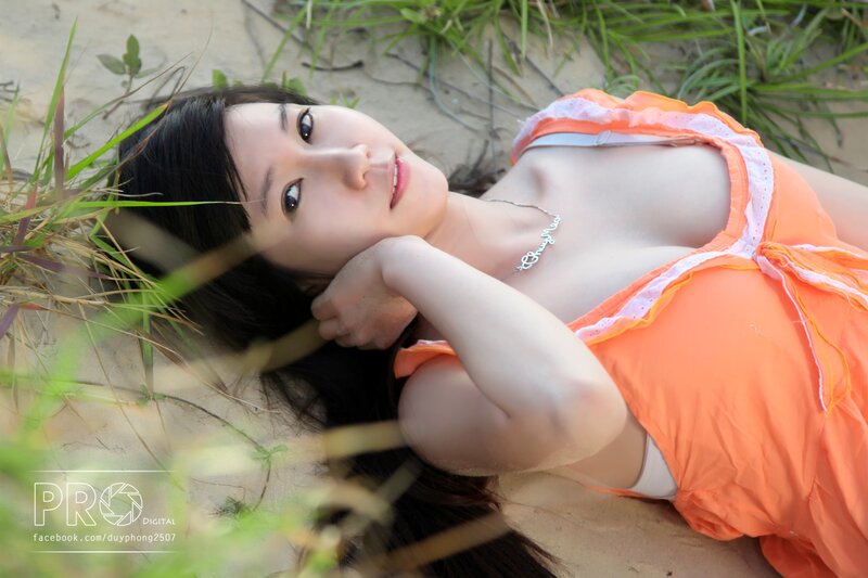 woman in orange dress lying on sand
