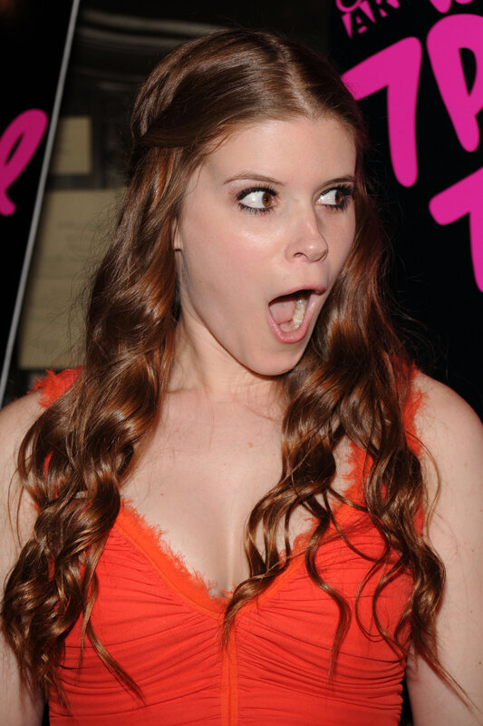 woman in orange dress making face