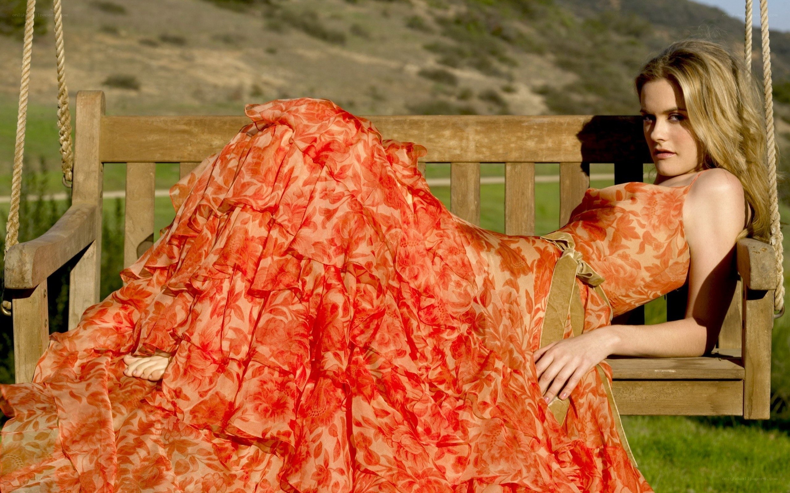 Woman in orange dress on swing