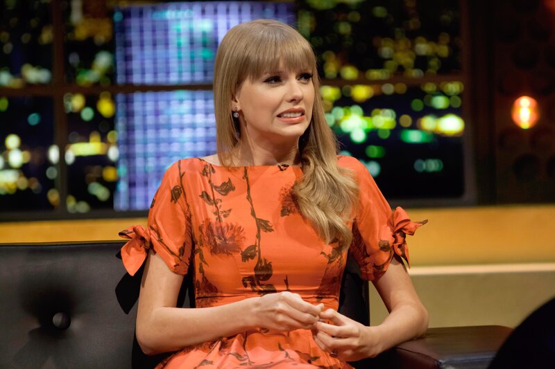 woman in orange dress on talk show