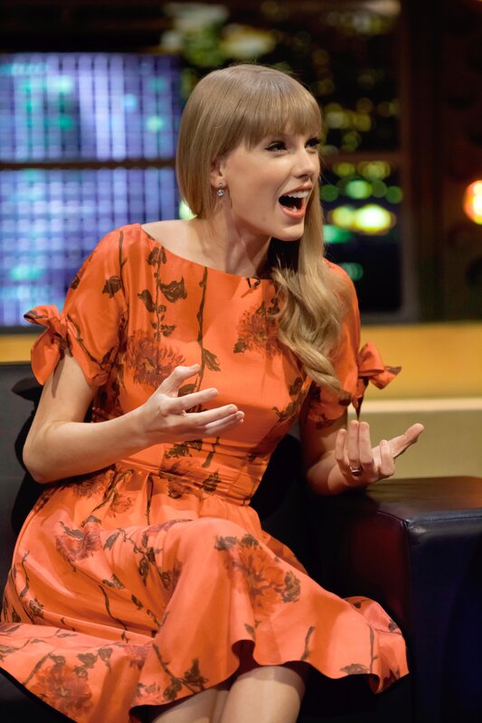 woman in orange dress on talk show
