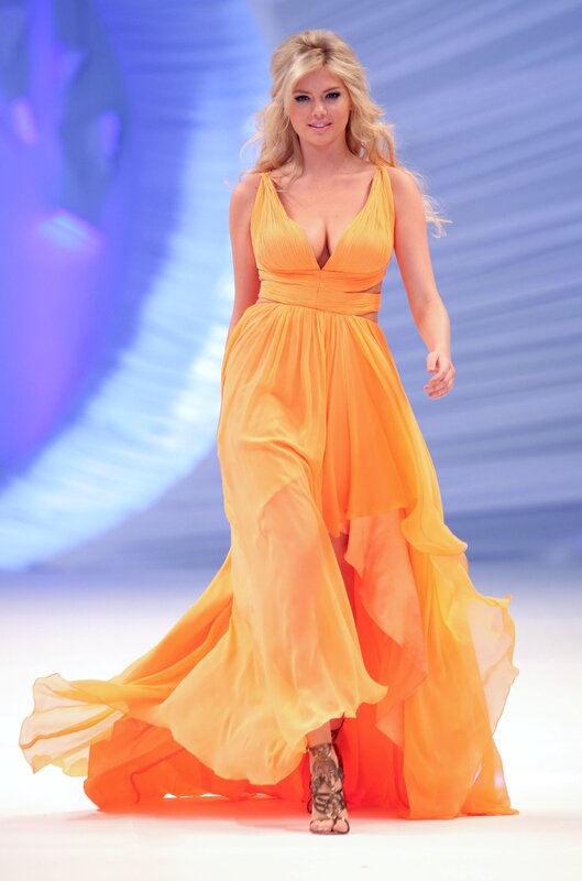 Woman in orange gown on runway