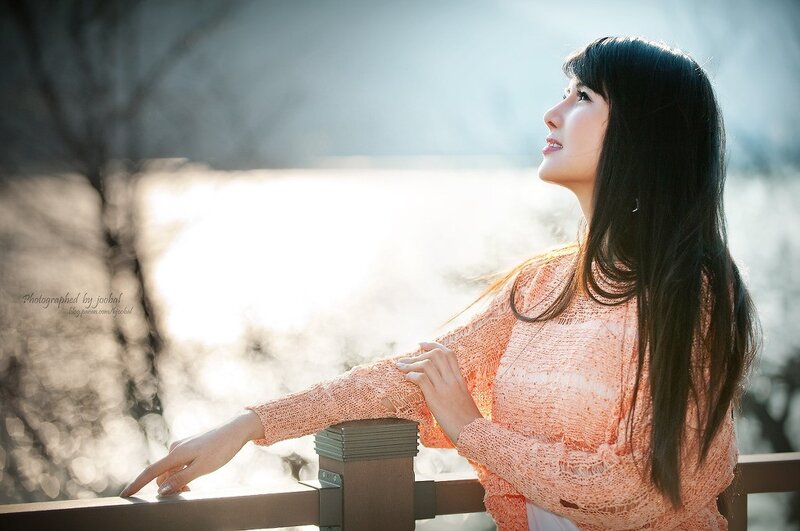woman in orange sweater at railing