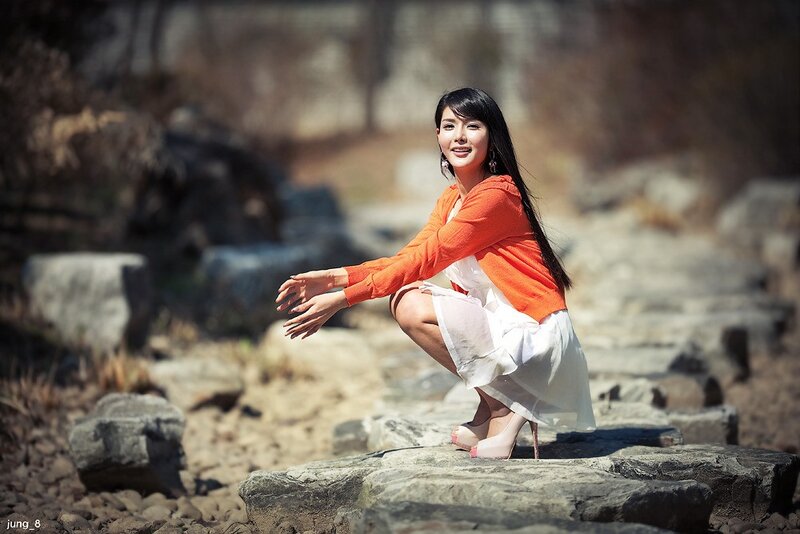 woman in orange sweater crouching