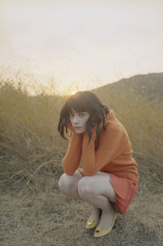 woman in orange sweater crouching