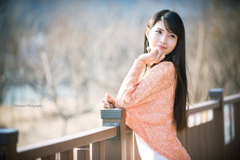 woman in orange sweater on balcony