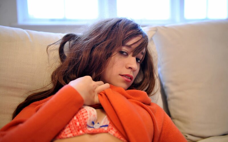 woman in orange sweater on couch