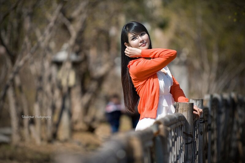 Woman in orange sweater outdoors