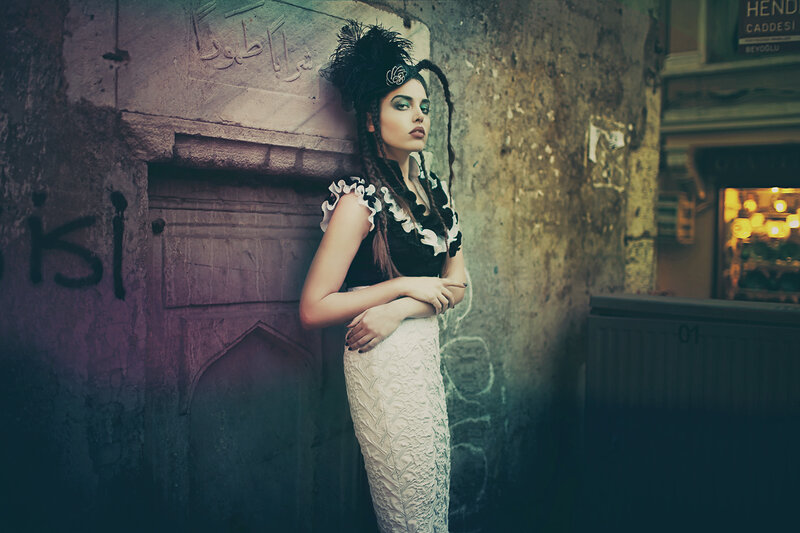 woman in ornate dress against stone wall