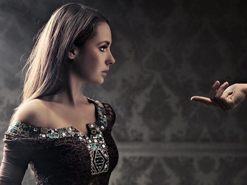 Woman in Ornate Dress — Black, Dramatic, Photograph, Hand Gesture, Patterned Wall