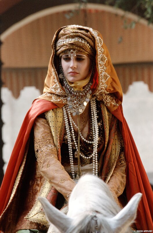 woman in ornate headwear on horseback