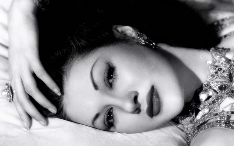 woman in ornate jewelry lying down