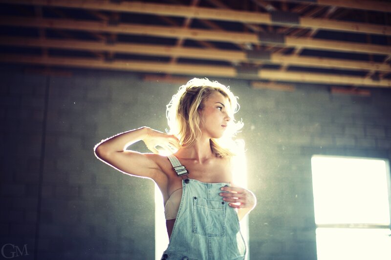 woman in overalls by window