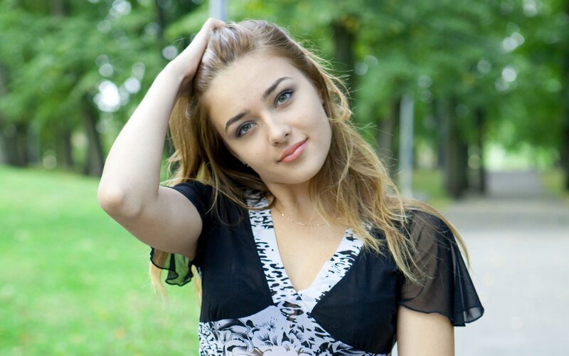 woman in park with hand on head