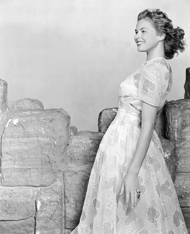 Woman in Patterned Dress — Black, Serene, Photograph, Stone Wall