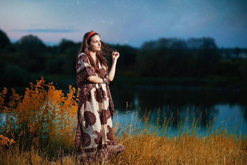 Woman in patterned dress by lake