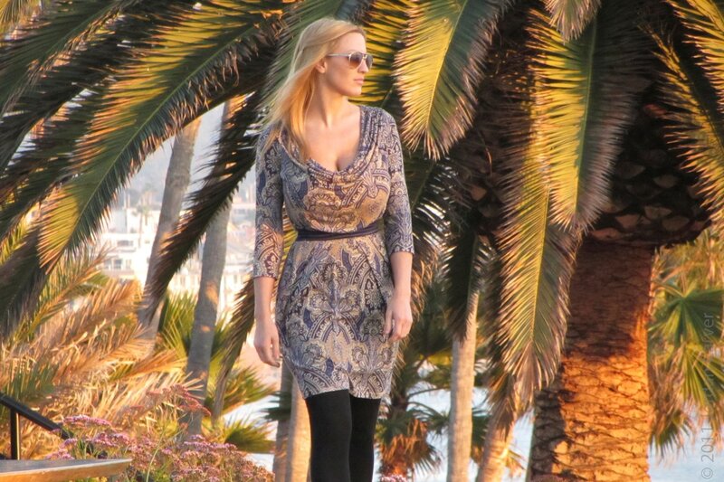 Woman in patterned dress near palm trees