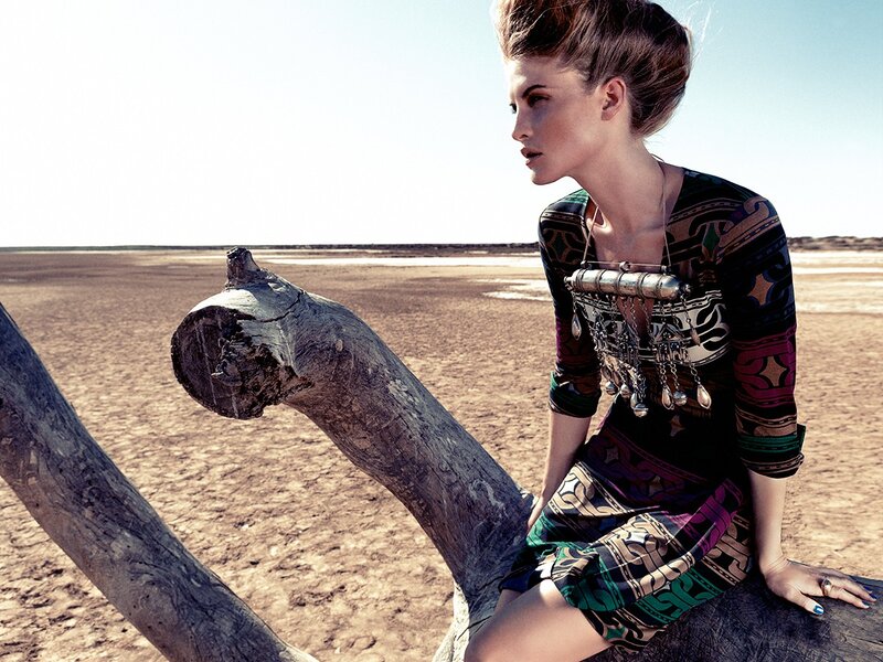 woman in patterned dress on driftwood