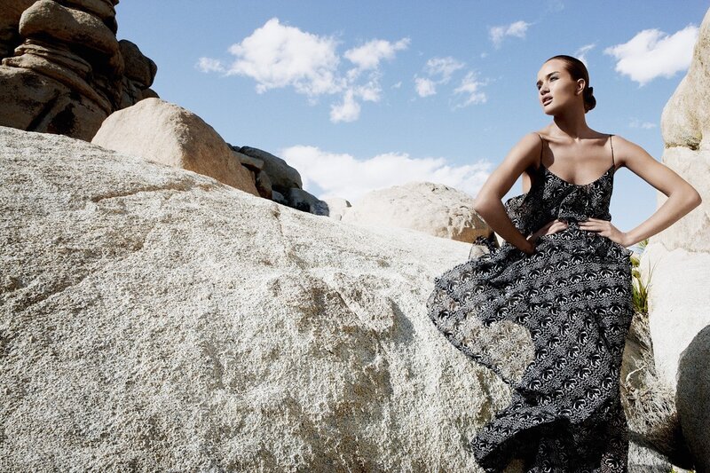 Woman in patterned dress on rocks