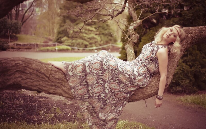 woman in patterned dress on tree branch