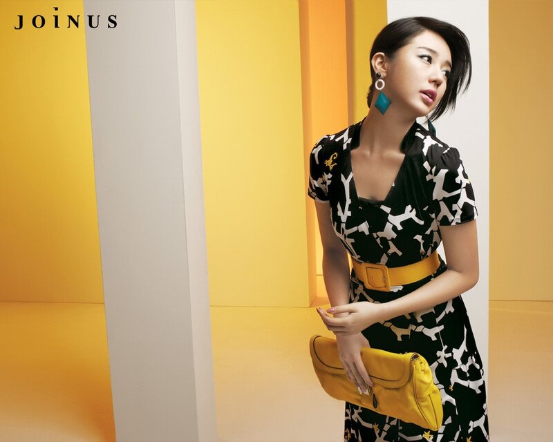 Woman in patterned dress with yellow clutch